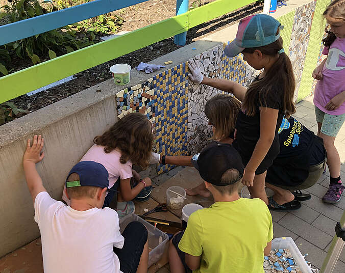 Kinder gestalten mit Mosaik Mauer.